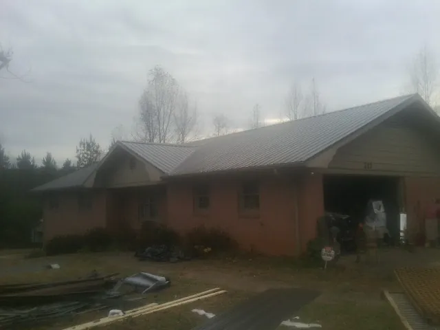 Gray metal roof on a stucco house with an attached garage in Farmington